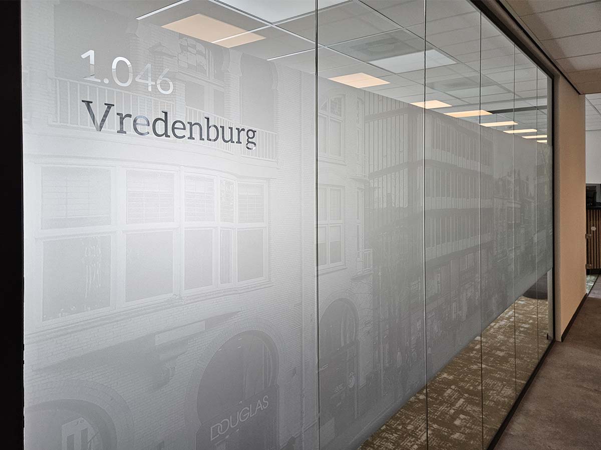 Een elegante glazen kantoorwand voorzien van matglasfolie met een subtiele zwart-wit print en uitgesneden kamernummer. Een stijlvolle, functionele privacyoplossing die licht doorlaat en perfect past bij moderne kantoorinterieurs.