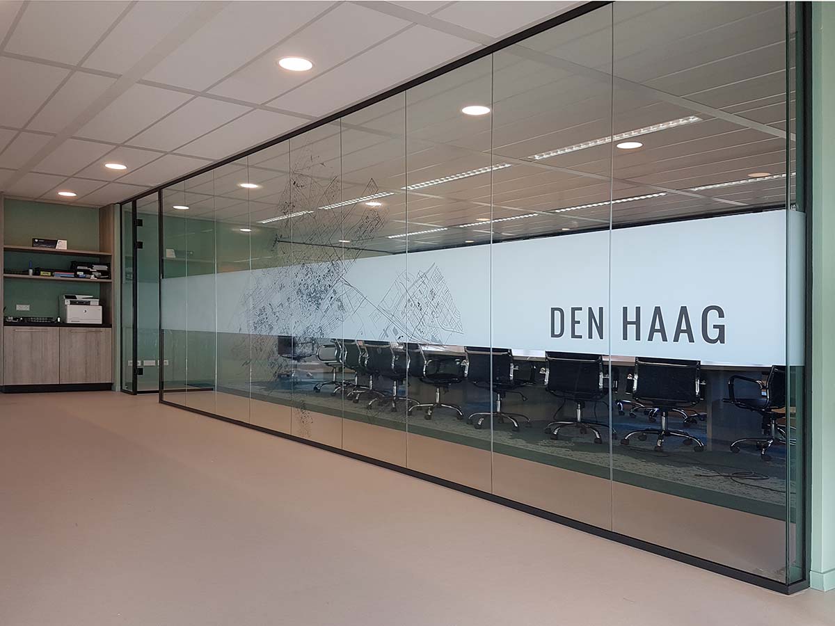 Raamfolie vergaderruimte met bedrukte stadsplattegrond en logo voor privacy en professionele uitstraling.