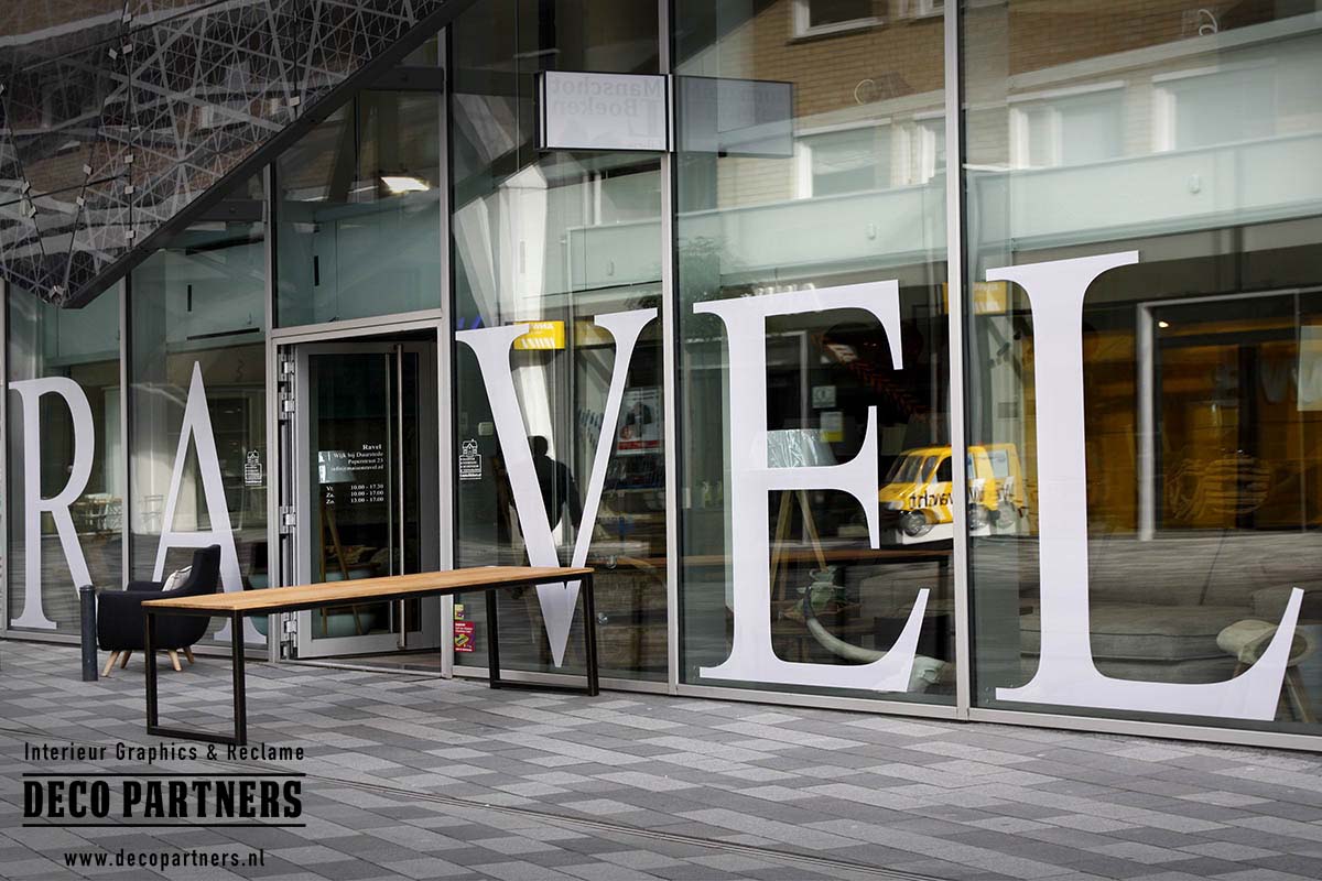 Grote contourgesneden raamletters van One Way Vision folie aangebracht op de glazen winkelpui van RAVEL.