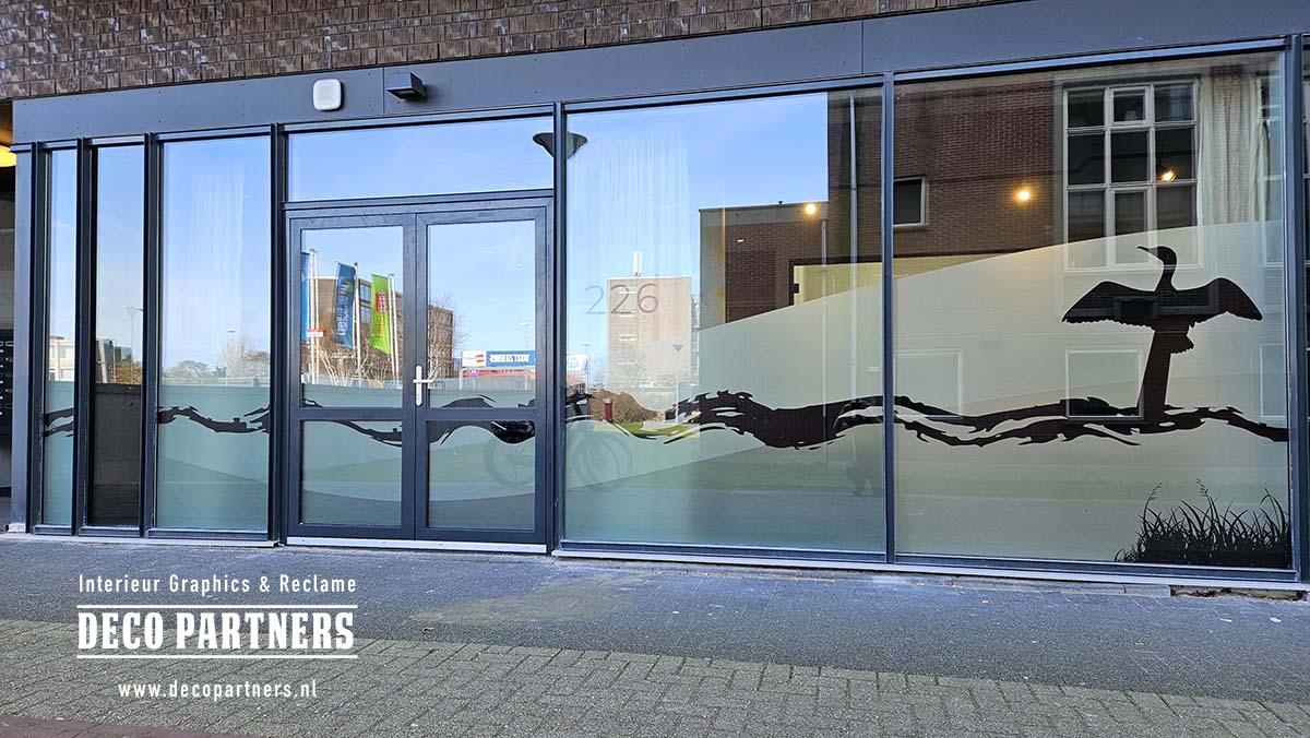 Maatwerk privacyfolie op maat voor een tandartspraktijk - gesneden matglasfolie met kustdesign waarbij de entreedeuren bewust lager zijn beplakt voor optimaal zicht op de ingang
