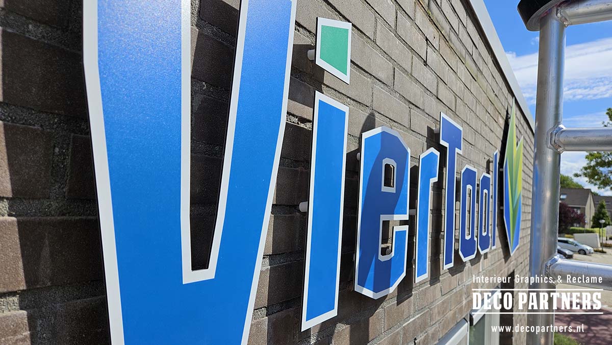 Zijaanzicht van direct bedrukte losse gevelletters gemonteerd op de bakstenen schoolgevel