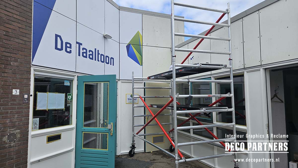 Montage van kleurrijke wrapfolie op bestaande gevelplaten van een schoolgebouw