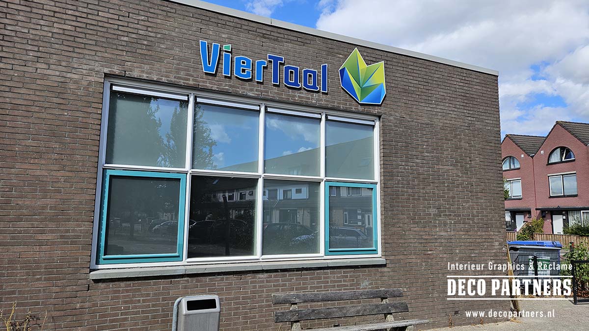 Nieuwe blauwe VierTaal gevelletters en kleurrijk beeldmerk rechtstreeks op de bakstenen gevel