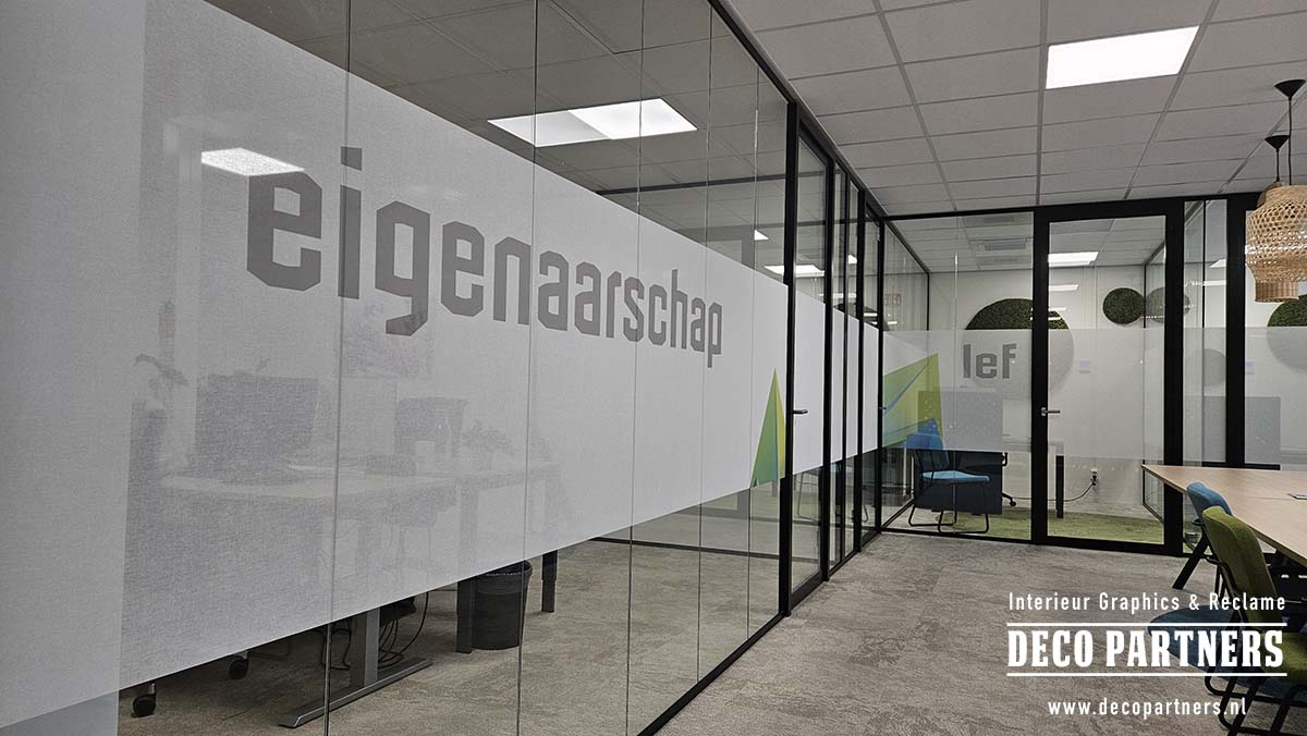Textiel raamfolie bedrukt met woorden en grafische vormen uit de huisstijl op glazen kantoorwanden