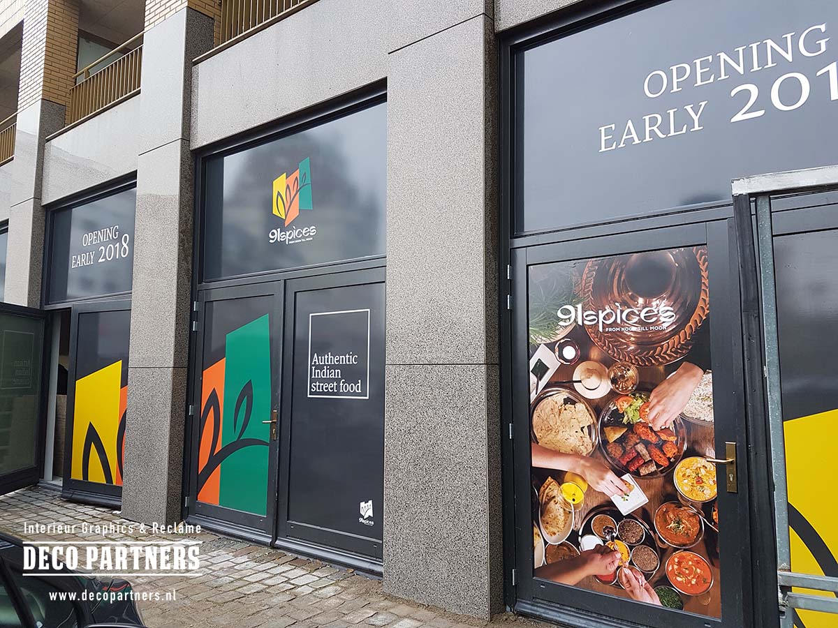 Tijdelijke fullcolour raambestickering op winkelramen en deuren tijdens een verbouwing voorafgaand aan de opening.
