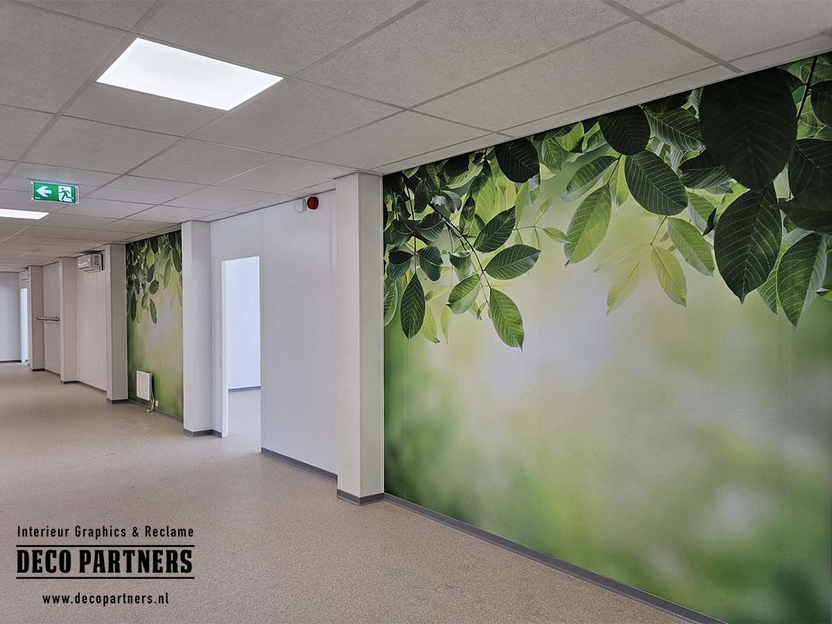 Grote verwijderbare wandprints met groene bladeren in een kinderopvang in tijdelijke modulaire huisvesting.