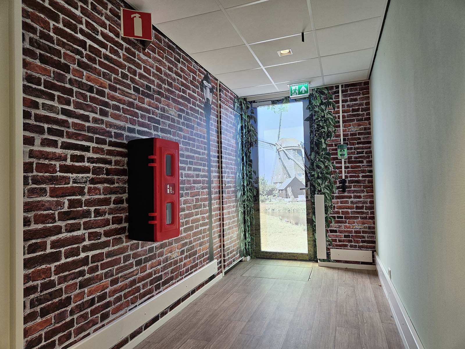Een sfeervolle gang met landelijk thema: de muurstickers en deurprint met molen brengen herkenning en warmte in de woonomgeving.