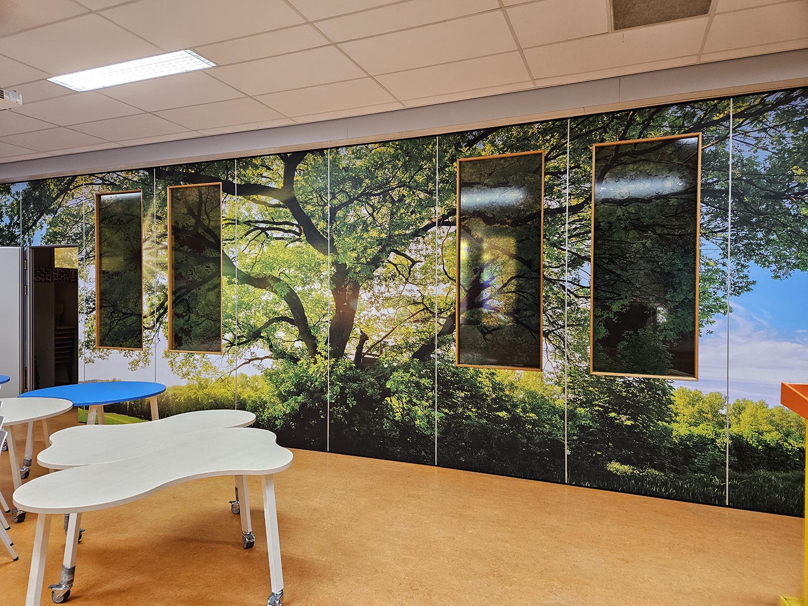 Voltooide folieprint makeover van de schoolaula wand in Utrecht met natuurthema.