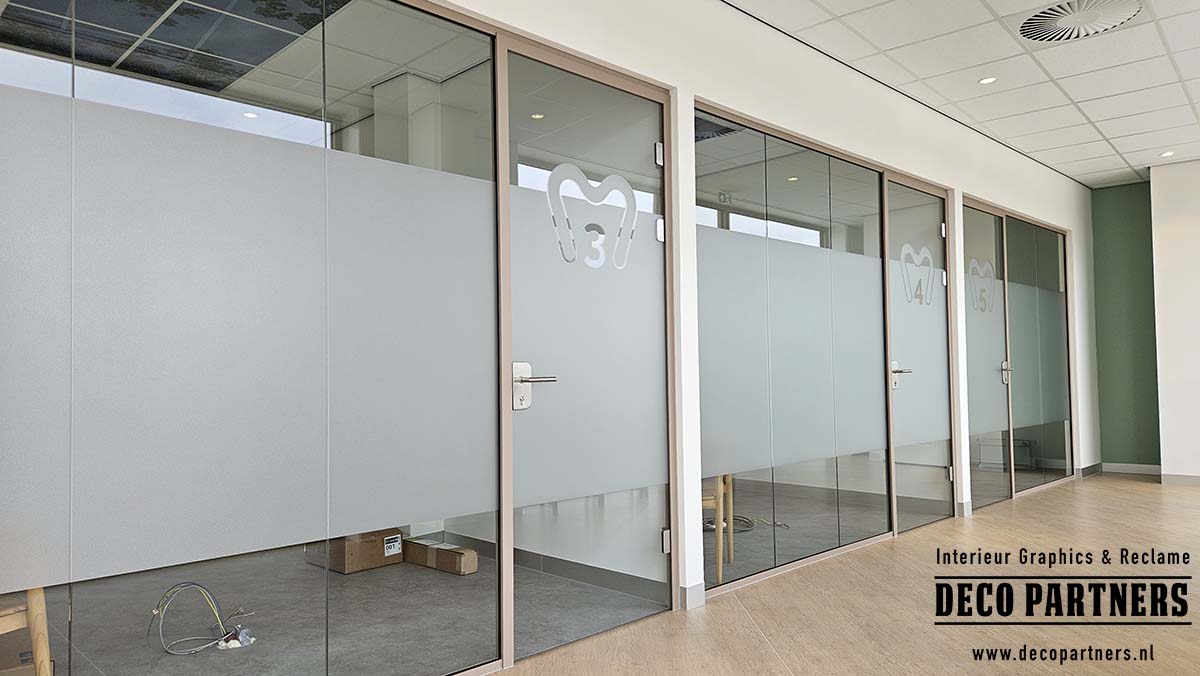 Zandstraalfolie op glazen wanden van behandelkamers in een tandartspraktijk voor privacy met behoud van daglicht.